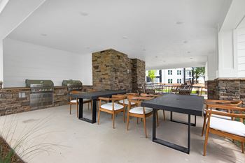 the pavilion dining area with tables and chairs and a brick fireplace at The Enclave at Deer Moss Creek, Niceville, FL